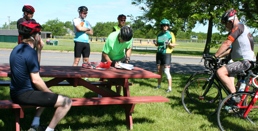 bike riders standing, listening